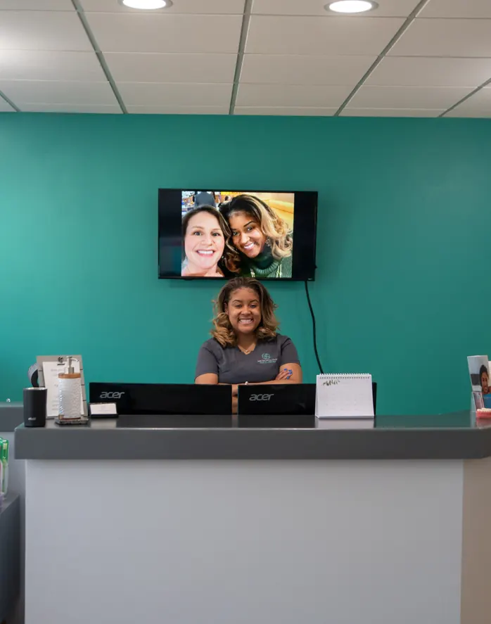 A smiling team member at the front desk of Metropolitan Dental Centre